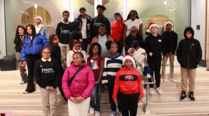 Twenty-two youth standing on a staircase smiling and posing in profile