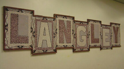 A framed mosaic spelling out the word "Langley" in a hallway