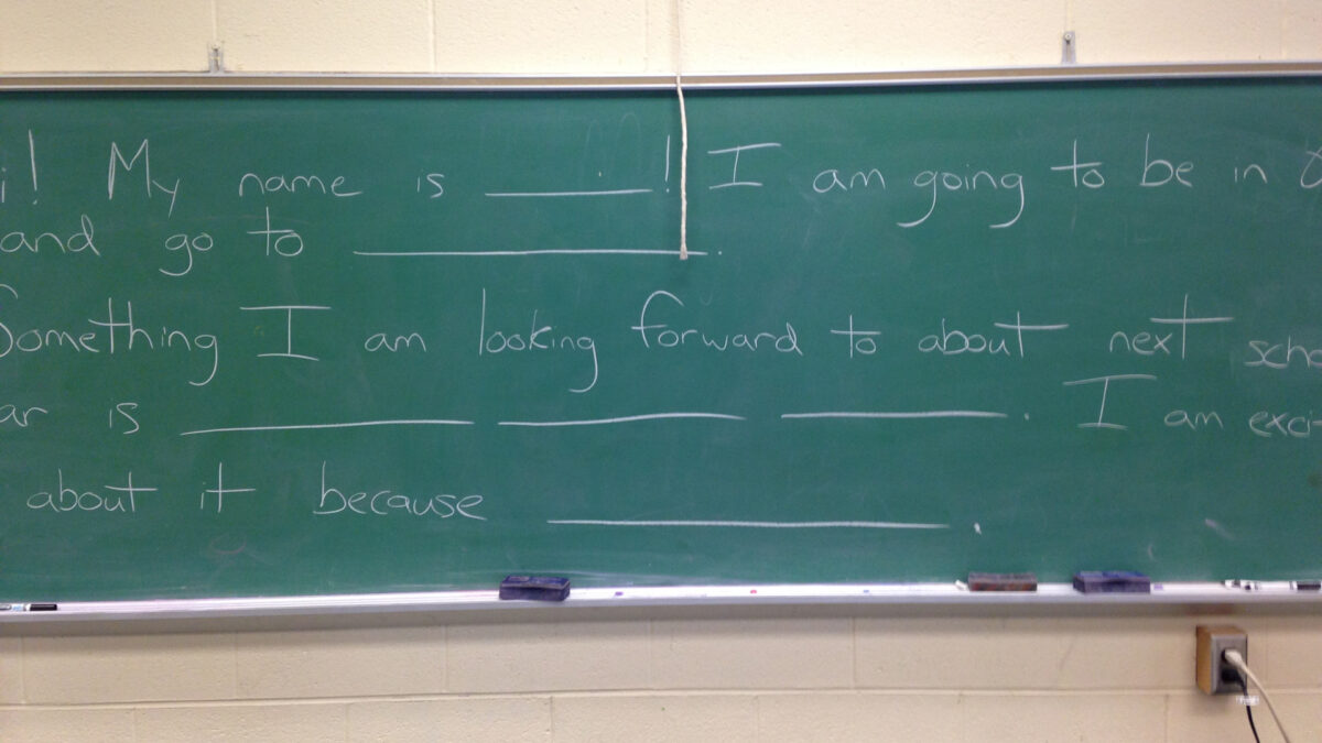 Text written on a green chalkboard in a classroom