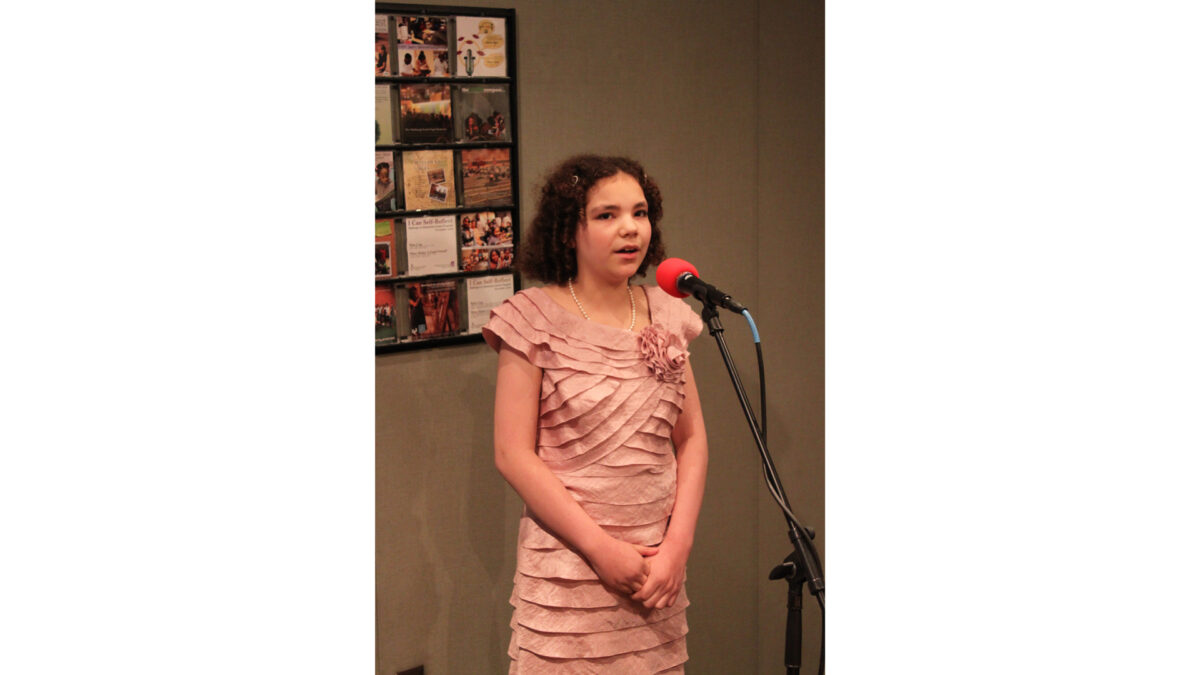 A youth singing into a microphone in a radio studio