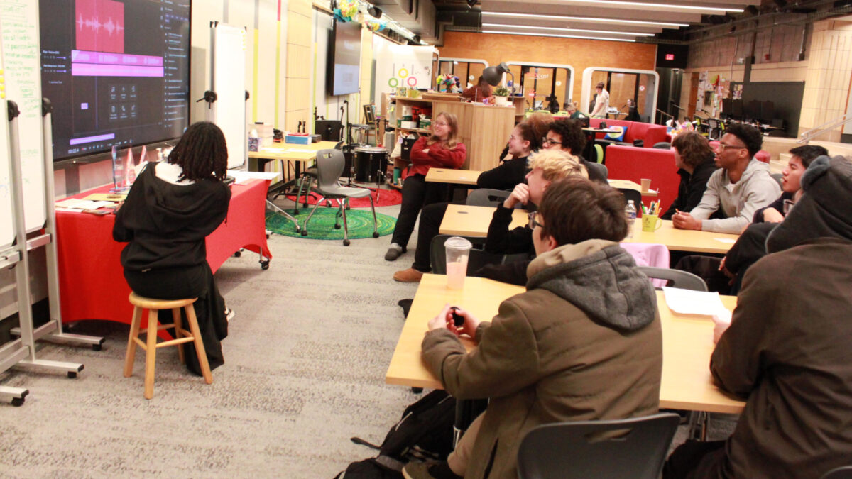 Ten teens looking at audio editing software on a large screen