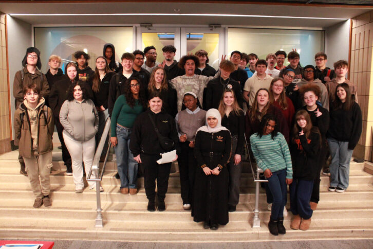 Thirty-eight teens smiling and posing on a staircase