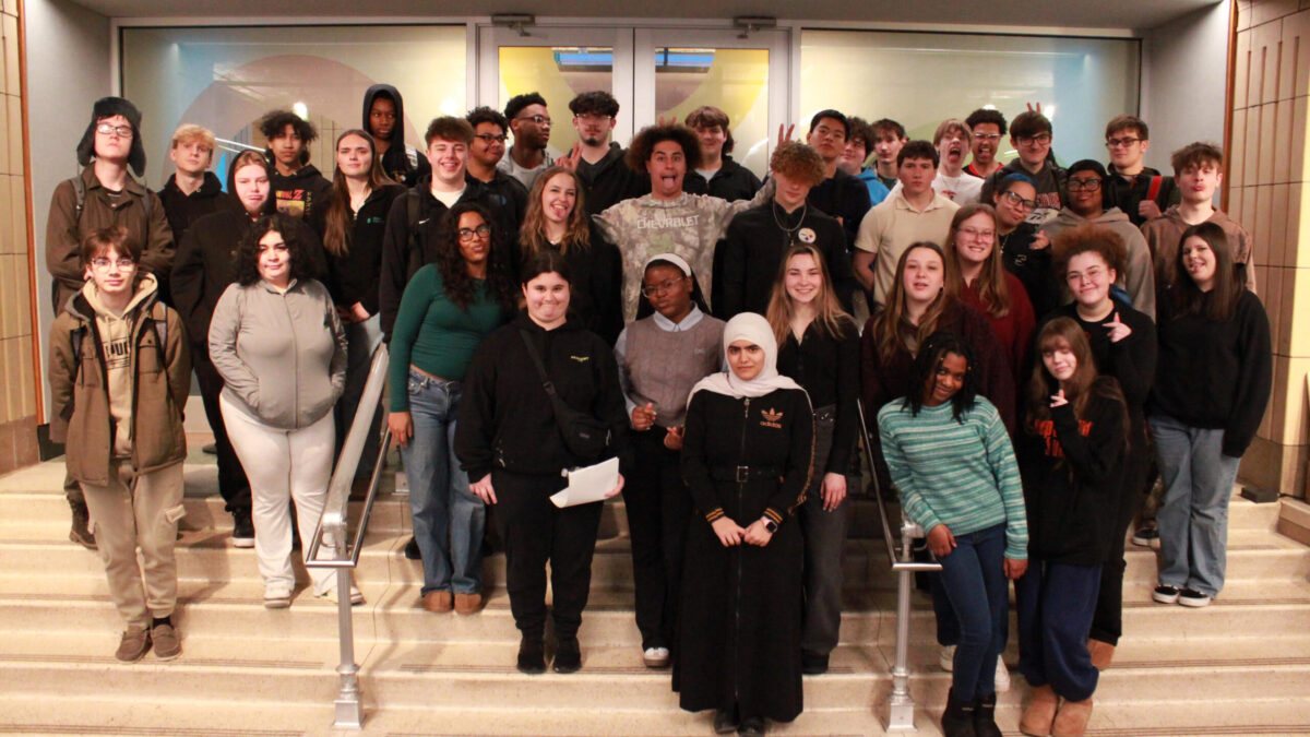 Thirty-eight teens smiling and posing on a staircase
