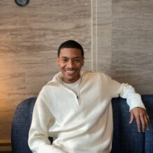 Person with light colored shirt posing on a blue chair.