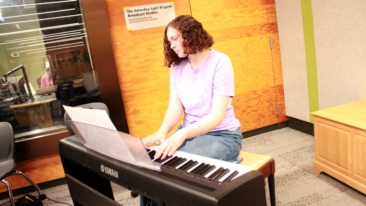 A teen playing a piano keyboard