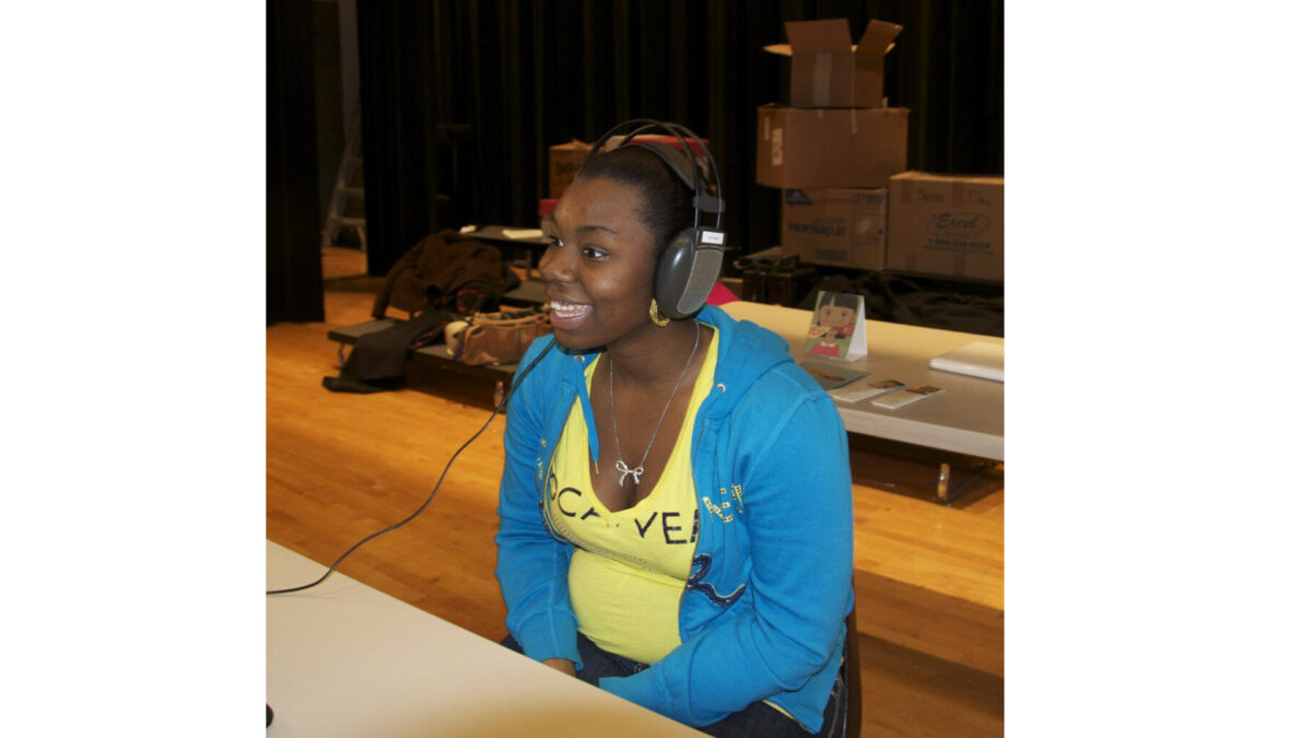 A teen wearing a pair of headphones and smiling