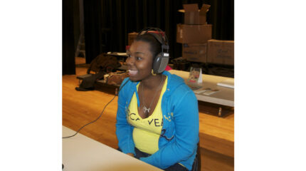 A teen wearing a pair of headphones and smiling