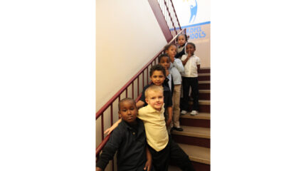 Seven youth posing on a brown staircase
