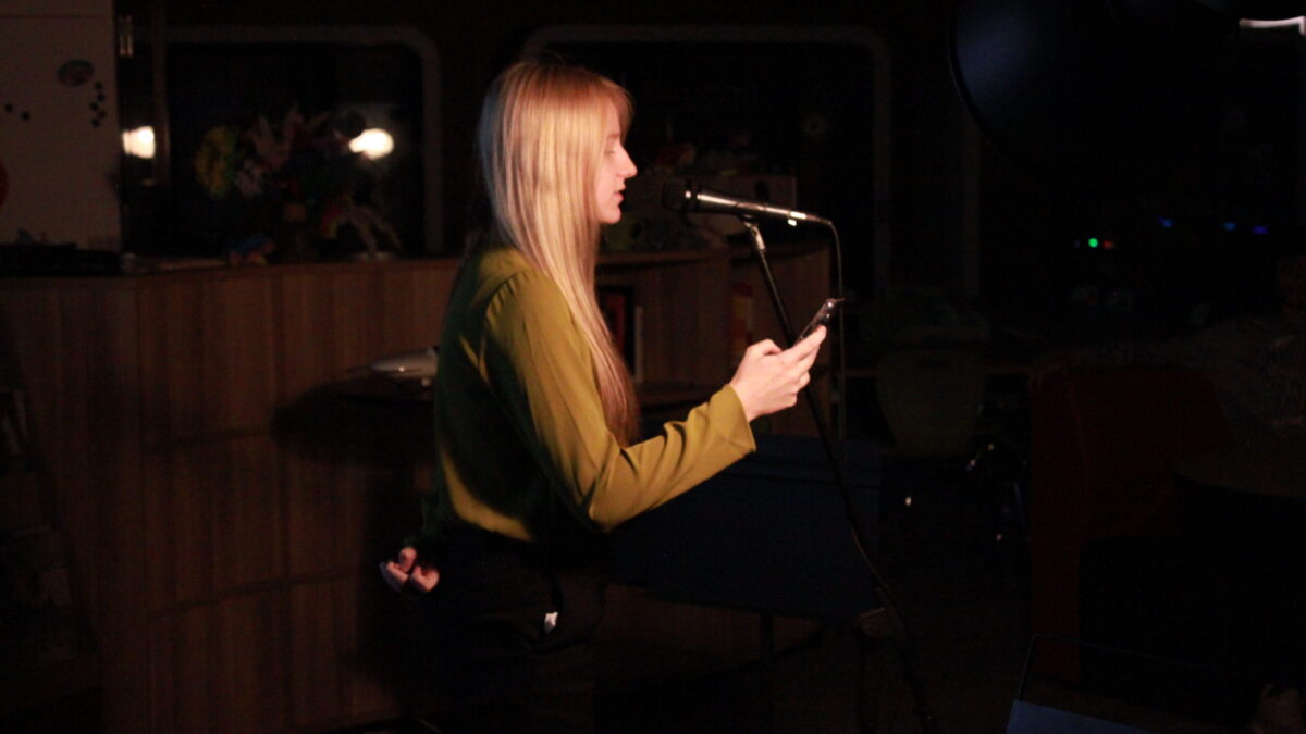A teen reading from their smartphone into a microphone