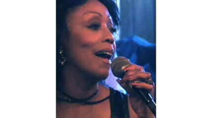 An adult singing into a microphone