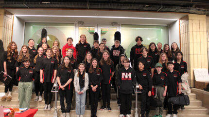Thirty five youth smiling and standing on a staircase