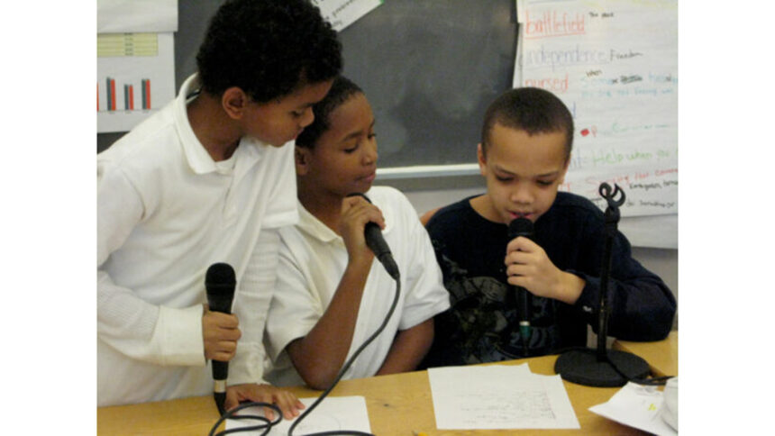 Three youth holding microphones in a classroom