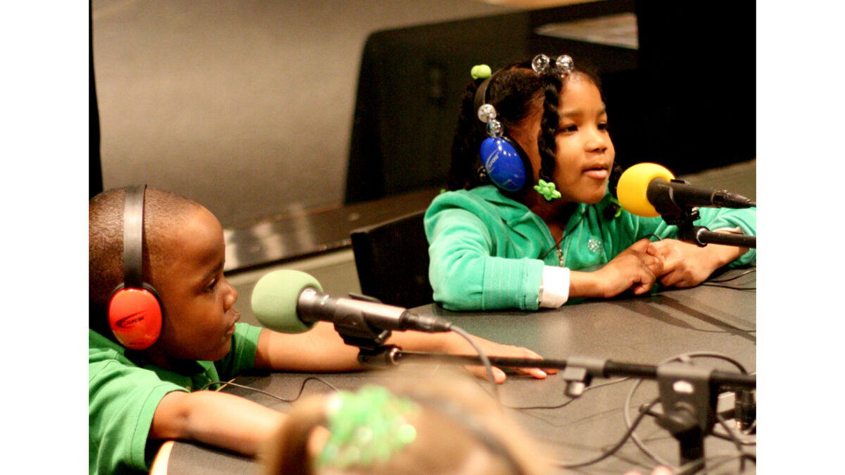 spark-animaldiscussion-02small_wp Two youth wearing headphones speaking into microphones in a radio studio