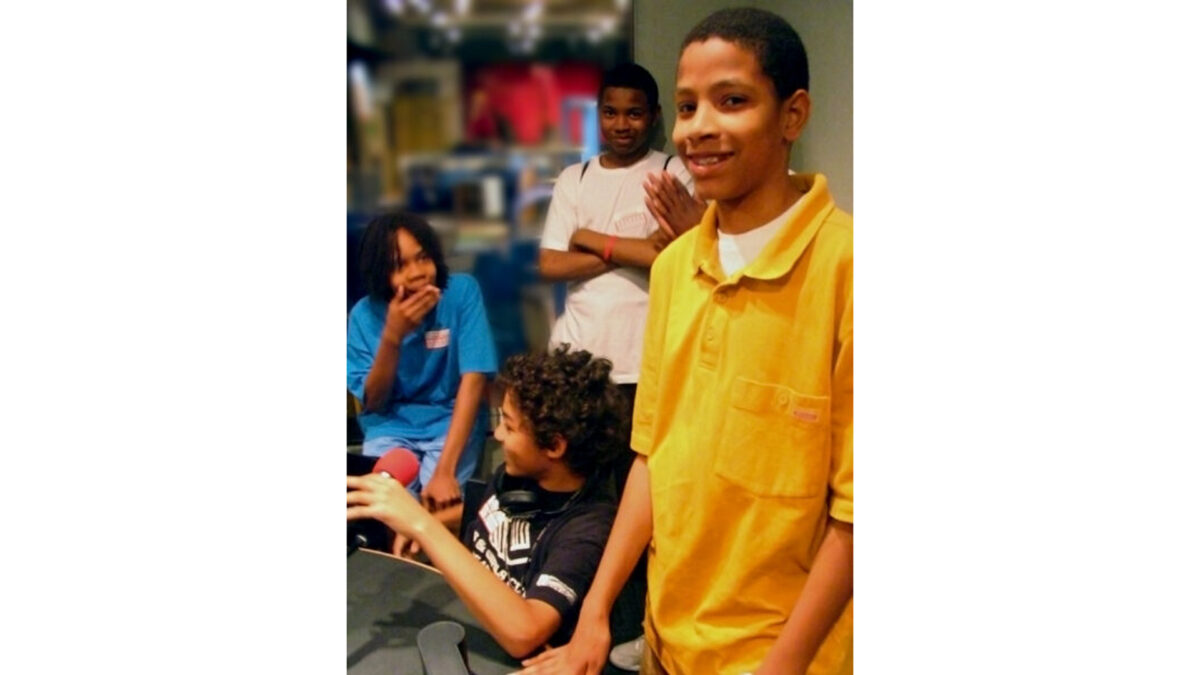 0176_wp Four youth standing around a microphone in a radio studio