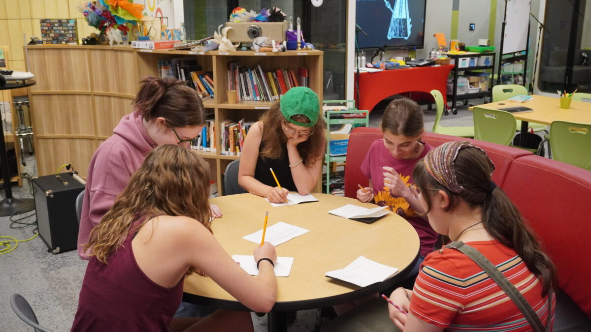 Rhyme and Reason-8 five teens write at a table together