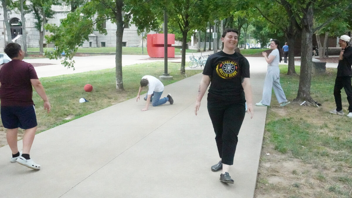 FYV-5 A youth and three adults standing around an adult on their knees in a park
