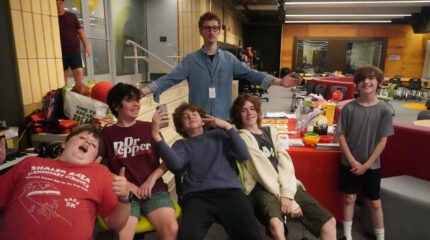 Five youth and an adult smiling and posing
