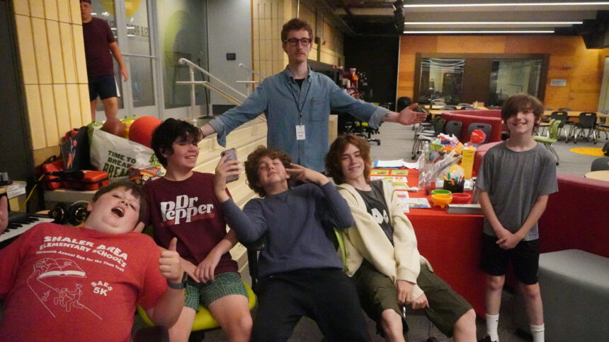 Five youth and an adult smiling and posing