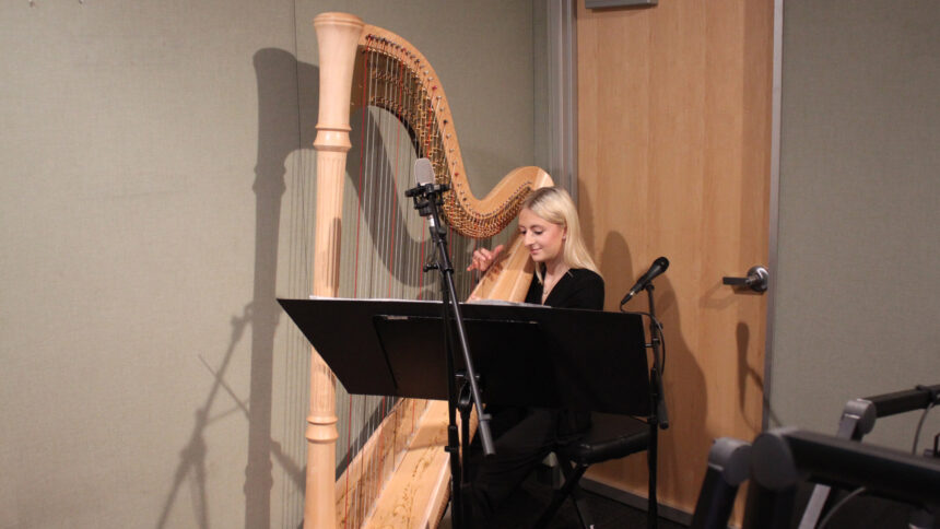 A teen playing a harp in a radio studio