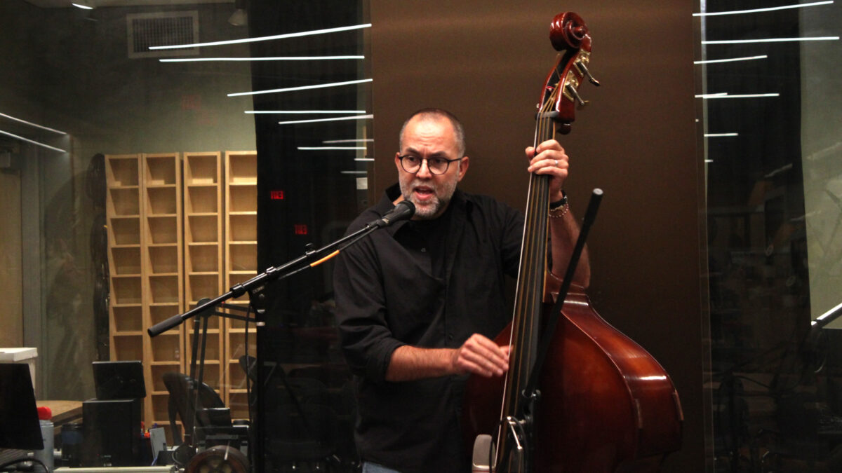 City-Holler-Band-2 An adult playing upright bass and singing into a microphone