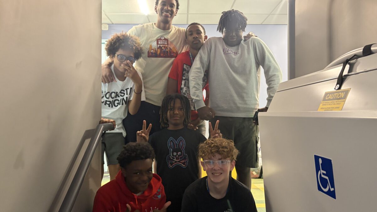 IMG_1989 Seven youth posing and smiling at the camera in a stairwell