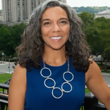 Person with dark hair and blue dress.