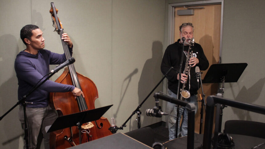 An adult playing an upright bass and an adult playing a bass clarinet in a radio studio